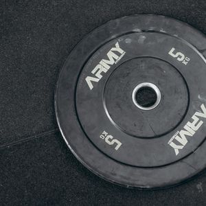A set of black kettlebells neatly arranged on a gym floor.